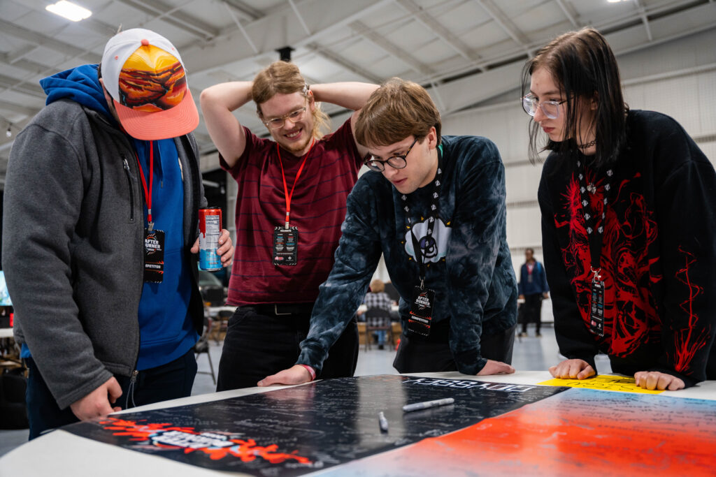 A group looks at the one of a kind Afterburner signature posters.